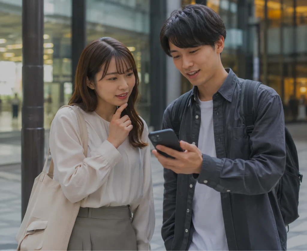 駅前でスマートフォンを見ながらお店を探す様子